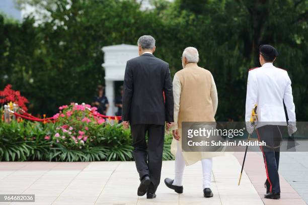 Indian Prime Minister Narendra Modi walks back after inspecting the guard of honour, accompanied by Singapore Prime Minister, Lee Hsien Loong during...