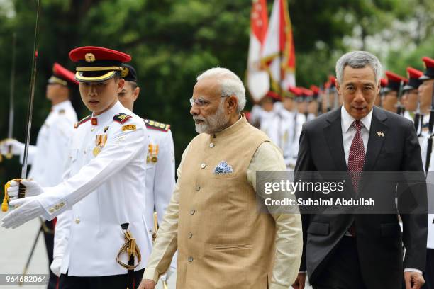 Indian Prime Minister Narendra Modi walks back after inspecting the guard of honour, accompanied by Singapore Prime Minister, Lee Hsien Loong during...