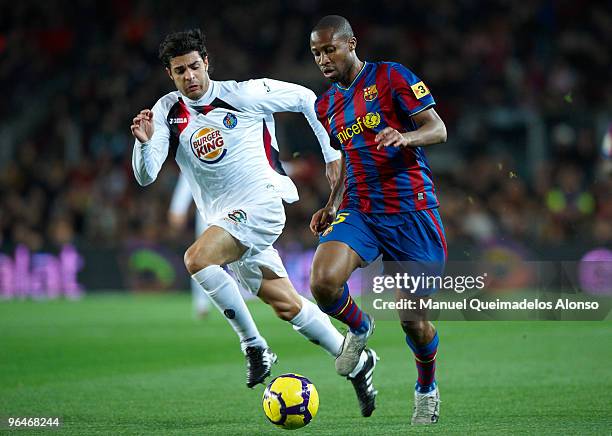 Seidou Keita of FC Barcelona competes for the ball with Miguel Torres of Getafe during the La Liga match between Barcelona and Getafe at Camp Nou on...