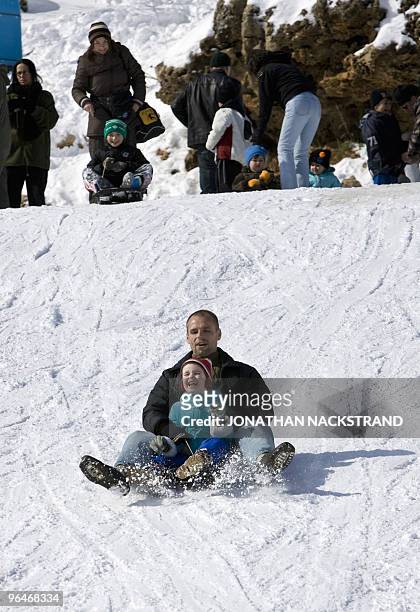 An Israeli man and his child slide down a slope at Mount Hermon in the northern Golan Heights on February 6, 2010. AFP PHOTO/JONATHAN NACKSTRAND