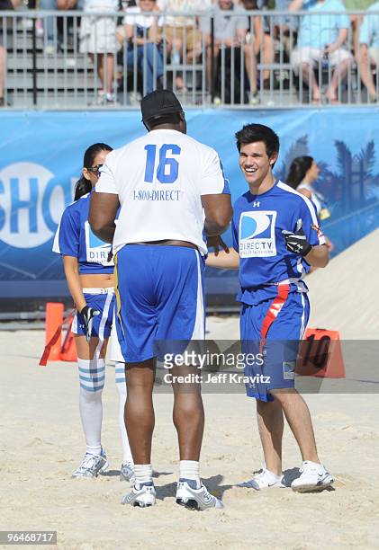 Actor Michael Clarke Duncan and actor Taylor Lautner talk on the field at DIRECTV's 4th Annual Celebrity Beach Bowl on February 6, 2010 in Miami...