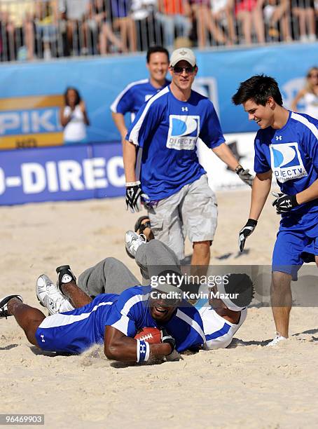 Former NFL player Eric "Big E" Ogbogu, with the ball is tackled by Marlon Wayans and Taylor Lautner at the DIRECTV's 4th Annual Celebrity Beach Bowl...