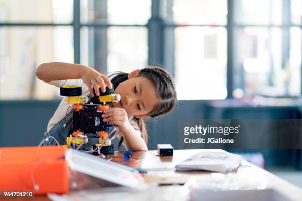 jong meisje gewerkt aan het ontwerp van een robot - girl school stockfoto's en -beelden