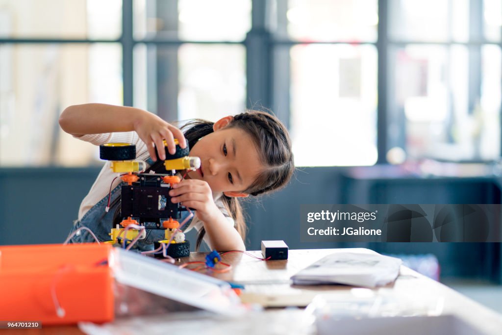 Young girl working on a robot design