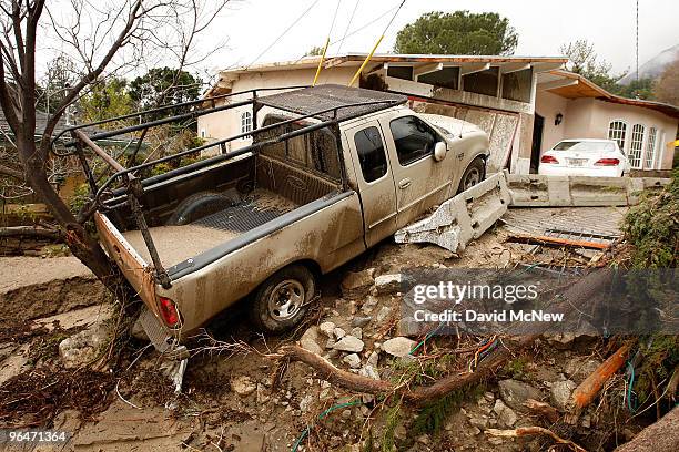 Debris flow damages homes and carries cars away on after heavy rains caused mudslides February 6, 2010 in La Canada Flintridge, California. Large...