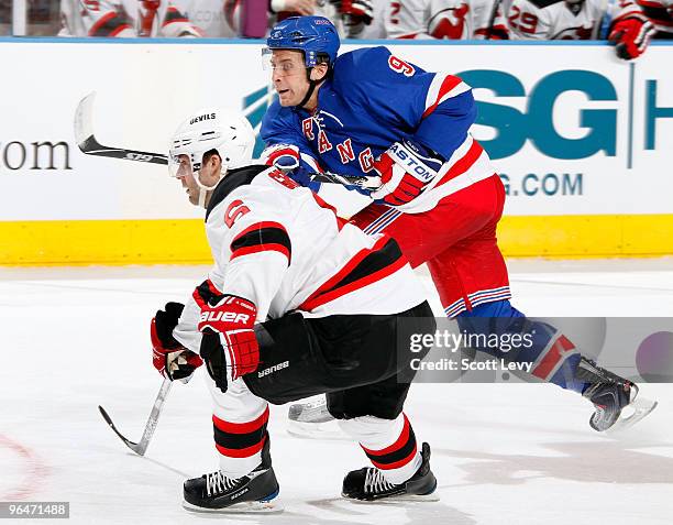 Matt Gilroy of the New York Rangers races for the puck against Andy Greene of the New Jersey Devils in the first period on February 6, 2010 at...