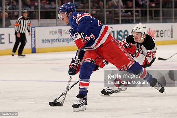 Ryan Callahan of the New York Rangers shoots a goa under pressure from Vladimir Zharkov of the New Jersey Devils during their game on February 6,...