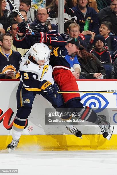 Toni Lydman of the Buffalo Sabres attempts to stand his ground against a rushing Jared Boll of the Columbus Blue Jackets during the second period on...