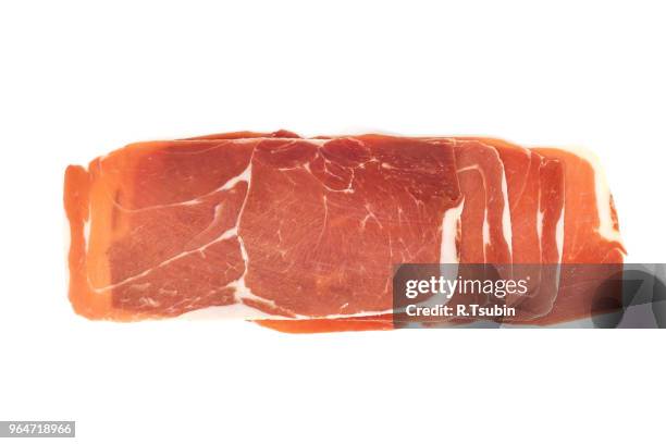 closeup on a piece of spanish serrano ham, isolated on white - jamon stockfoto's en -beelden