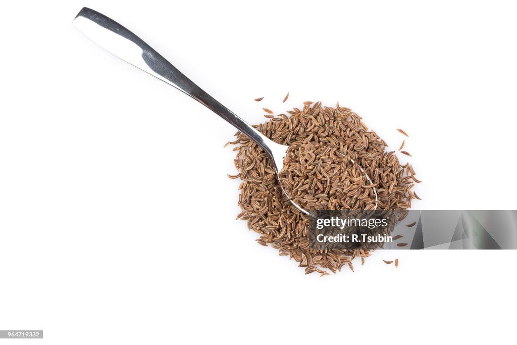 Pile of dry caraway seeds in spoon Isolated on white background