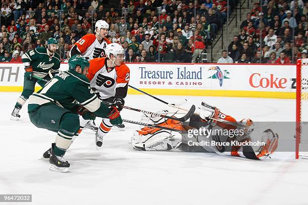 Kyle Brodziak of the Minnesota Wild narrowly misses the net after shooting the puck past goalie Michael Leighton of the Philadelphia Flyers during...