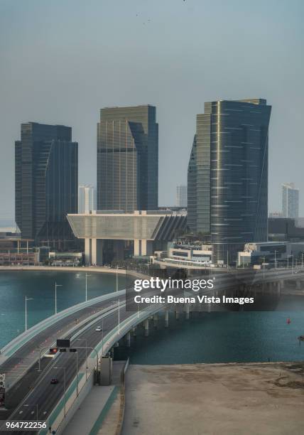 road over water connecting to futuristic skyscrapers - al maryah island in abu dhabi stockfoto's en -beelden