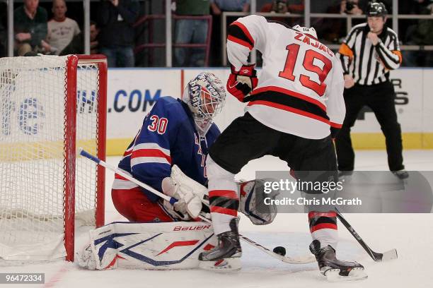 Henrik Lundqvist of the New York Rangers makes a save against Travis Zajac of the New Jersey Devils during their game on February 6, 2010 at Madison...