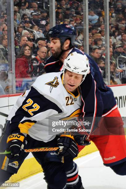 Mathieu Roy of the Columbus Blue Jackets finishes a check on Adam Mair of the Buffalo Sabres during the third period on February 6, 2010 at...