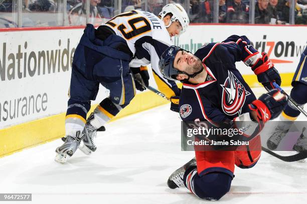 Mathieu Roy of the Columbus Blue Jackets falls after getting hit by a high stick by Jason Pominville of the Buffalo Sabres during the third period on...