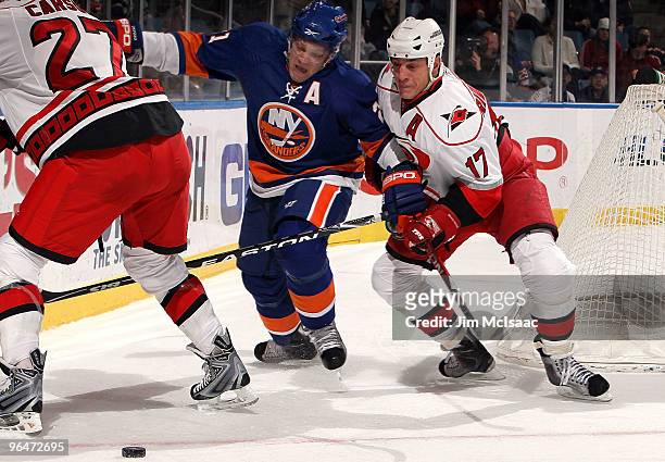Kyle Okposo of the New York Islanders battles for the puck against Rod Brind'Amour of the Carolina Hurricanes on February 6, 2010 at Nassau Coliseum...