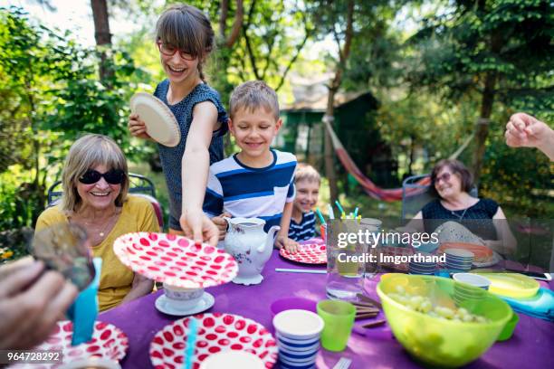 familie met barbecue in de tuin - papieren bord stockfoto's en -beelden