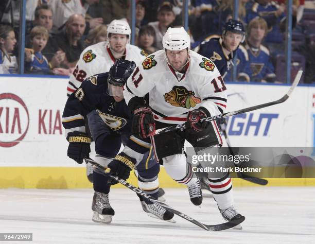 John Madden of the Chicago Blackhawks races Andy McDonald of the St. Louis Blues up ice on February 6, 2010 at Scottrade Center in St. Louis,...