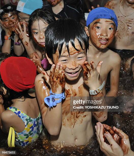 Visitors dab chocolate syrup on their faces at a "chocolate spa" at the Hakone Yunessun spa resort in Hakone town, Kanagawa prefecture, 100 km west...
