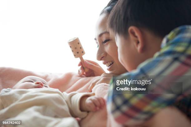the baby is being entertained with a toy. - baby rattle stock pictures, royalty-free photos & images