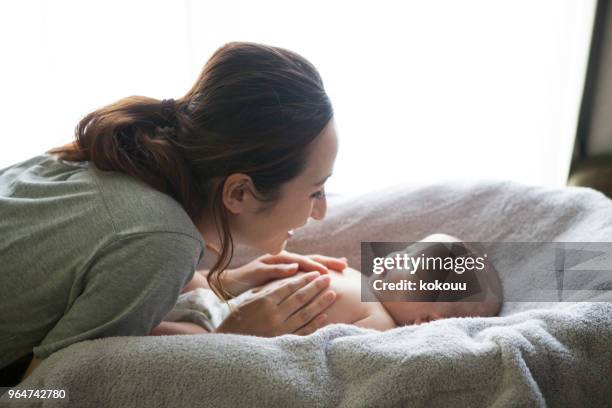 a hand touching a baby. - son massage mom imagens e fotografias de stock