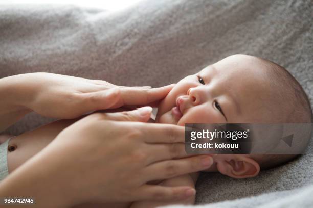 a hand touching a baby. - son massage mom imagens e fotografias de stock