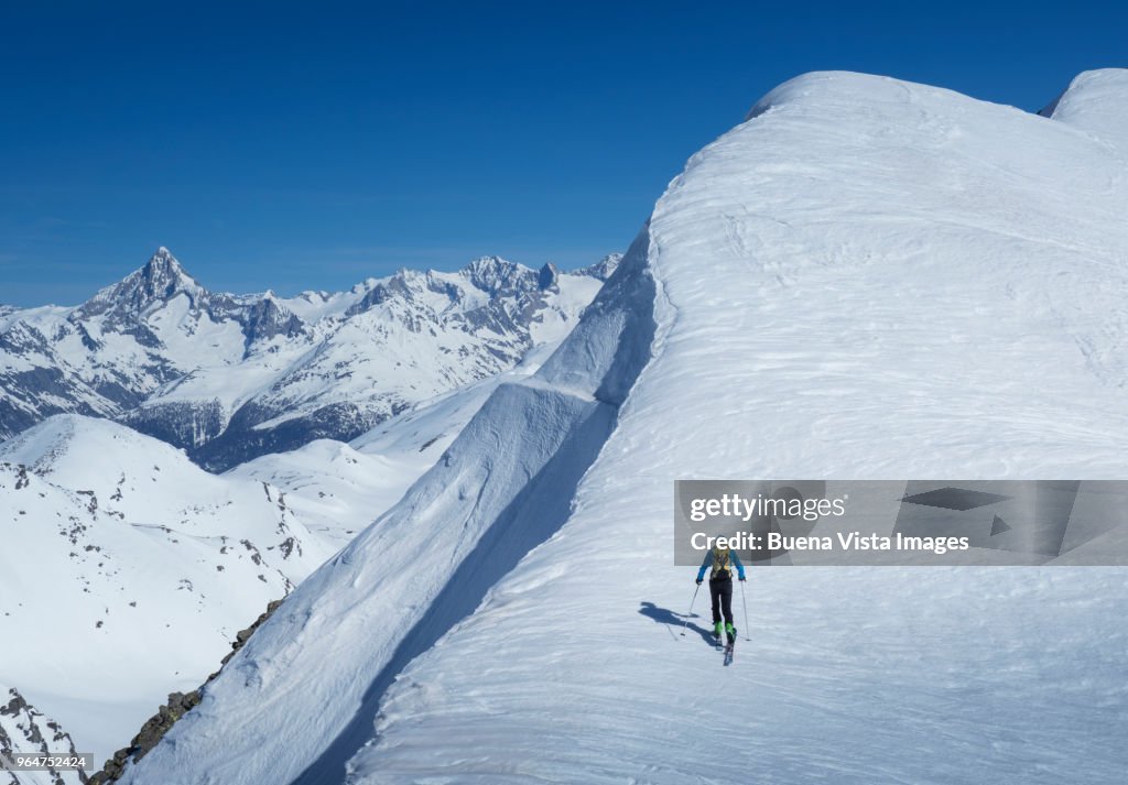 Senior skier ascending a snowy slope