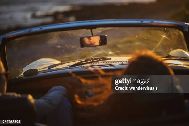 rear view mirror reflection of woman's lips in cabriolet car - woman rear view mirror stock pictures, royalty-free photos & images