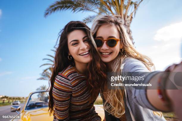 femmes jeunes hipster sur road trip s’amuser en tenant selfies - selfie young people photos et images de collection