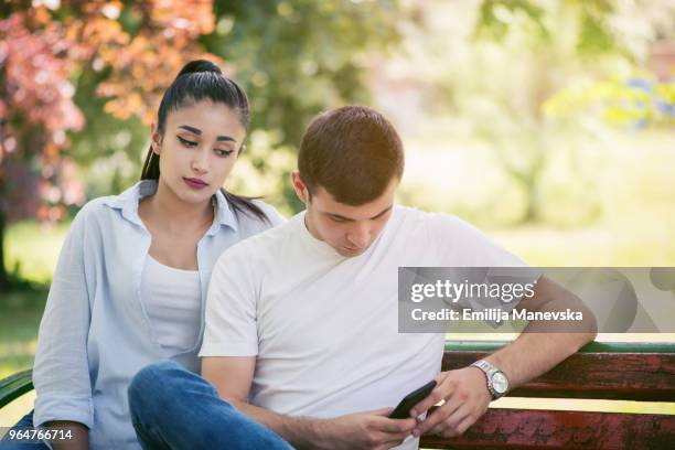 young woman spy on boyfriend cell phone - suspicion infidelity stock pictures, royalty-free photos & images