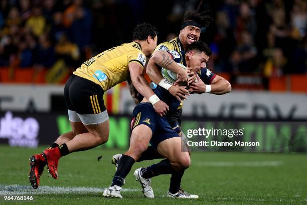 Rob Thompson of the Highlanders is tackled by Ardie Savea of the Hurricanes during the round 16 Super Rugby match between the Highlanders and the...