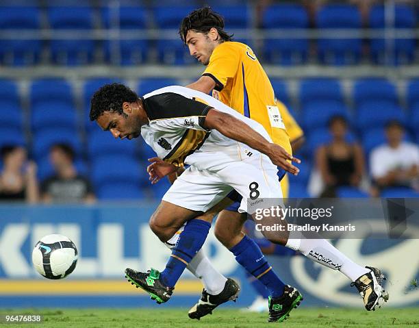 Paul Ifill of the Phoenix is tackled by Zenon Caravella of the Gold Coast during the round 26 A-League match between Gold Coast United and Wellington...