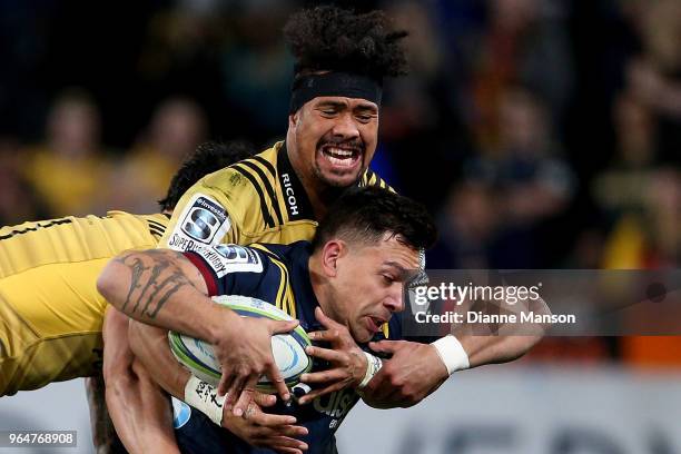 Rob Thompson of the Highlanders is tackled by Ardie Savea of the Hurricanes during the round 16 Super Rugby match between the Highlanders and the...