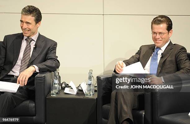 Secretary General of NATO Anders Fogh Rasmussen and German Defence Minister Karl-Theodor zu Guttenberg smile as they take part in a panel discussion...