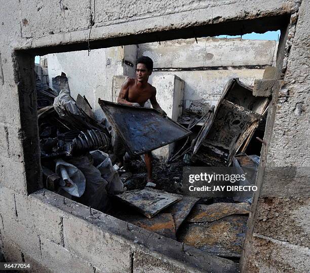 Resident looks for salvageable materials in the suburban Caloocan slum, north of Manila on February 7, 2010 in the debris after a fire gutted out a...