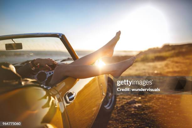 woman with feet sticking out convertible car relaxing on holidays - retro summer holiday stock pictures, royalty-free photos & images