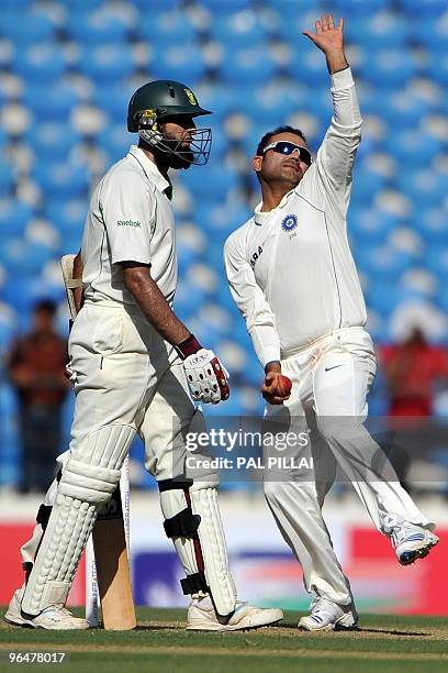 South African cricketer Hashim Amla looks on as Indian cricketer Virender Sehwag bowls on the second day of the first cricket Test match between...