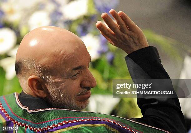 Afghan President Hamid Karzai waves to a participant prior to a panel discussion on Afghanistan at the 46th Munich Security Conference at the...