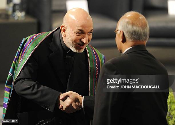 Afghan President Hamid Karzai greets India's National Security Advisor Shiv Shankar Menon prior to a panel discussion on Afghanistan at the 46th...