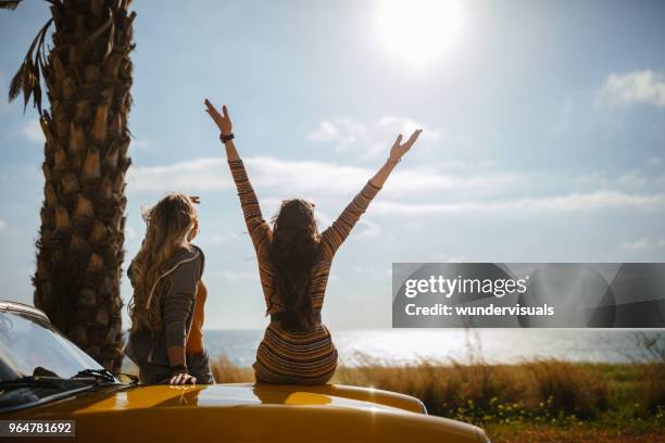 junge frauen auf reise, genießen sie die sonne am meer - arm sun beach stock-fotos und bilder