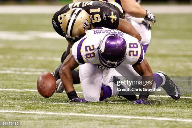 Adrian Peterson of the Minnesota Vikings fumbles the ball as he was hit by Jonathan Vilma of the New Orleans Saints during the NFC Championship Game...