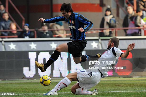 Diego Milito of Internazionale Milano and Michele Canini of Cagliari compete for the ball during the Serie A match between FC Internazionale Milano...