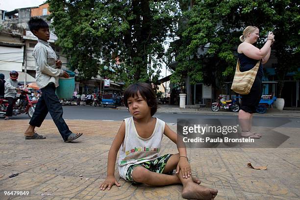 Sinal hangs out on the streets waiting for handouts as tourists walk to the National museum February 7, 2010 in Phnom Penh, Cambodia. Forced...