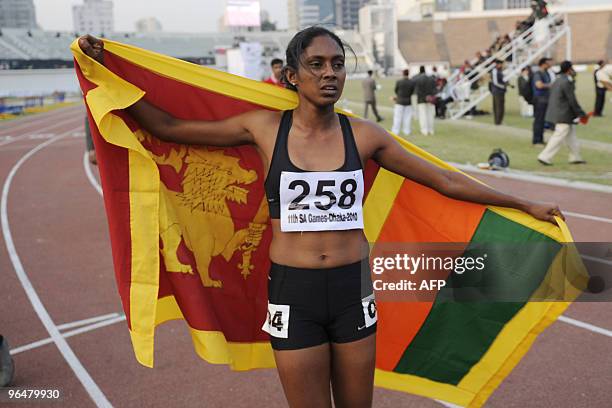 Sri lankan athlete Shandirika Subashihi Rasnayaka Mudiyanselage poses with the Sri Lankan flag after winning the gold in the women's 400m during the...