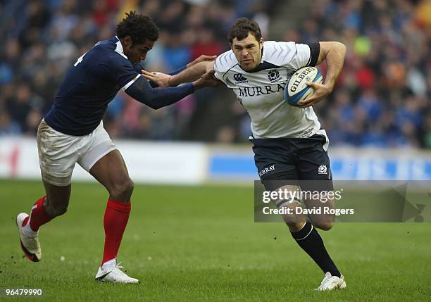 Sean Lamont of Scotland holds off the tackle of Benjamin Fall of France during the RBS Six Nations Championship match between Scotland and France at...