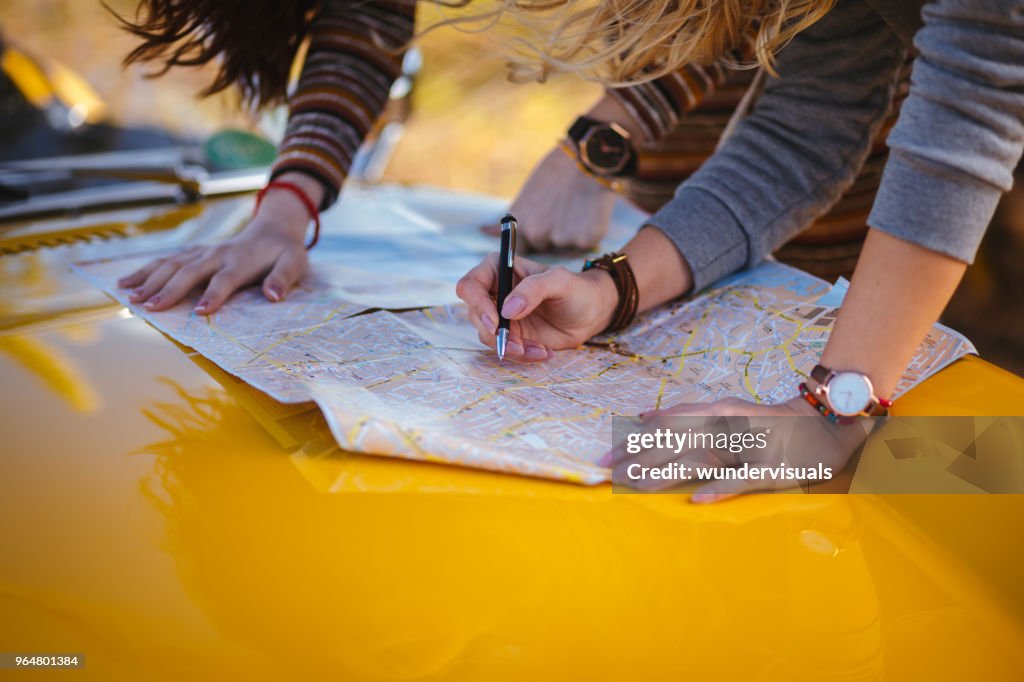 Mujeres en viaje de verano leyendo mapa para direcciones