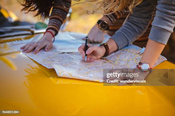 women on summer road trip reading map for directions - weekend activities imagens e fotografias de stock