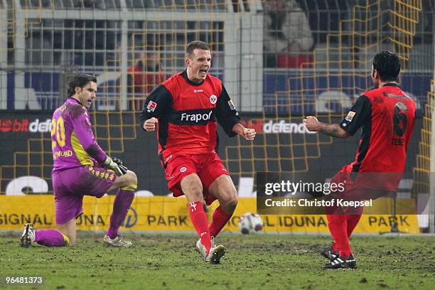 Alexander Meier of Frankfurt celebrates the third goal with Selim Teber of Frankfurt and Marc Ziegler of Dortmund looks dejected during the...