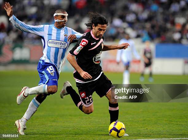 Deportivo Coruna's midfielder Juan Rodriguez gestures with Malaga's defender Mtiliga during a Spanish league football match at La Rosaleda's stadium...