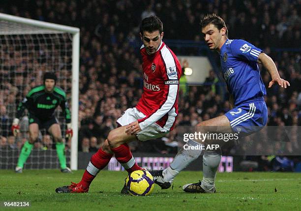 Branislav Ivanovic of Chelsea and Cesc Fabregas of Arsenal battle for the ball as Chelsea goalkeeper Petr Cech looks on during the English...